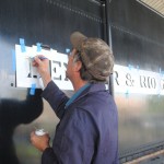 Lee Connor applies new lettering to the tender.